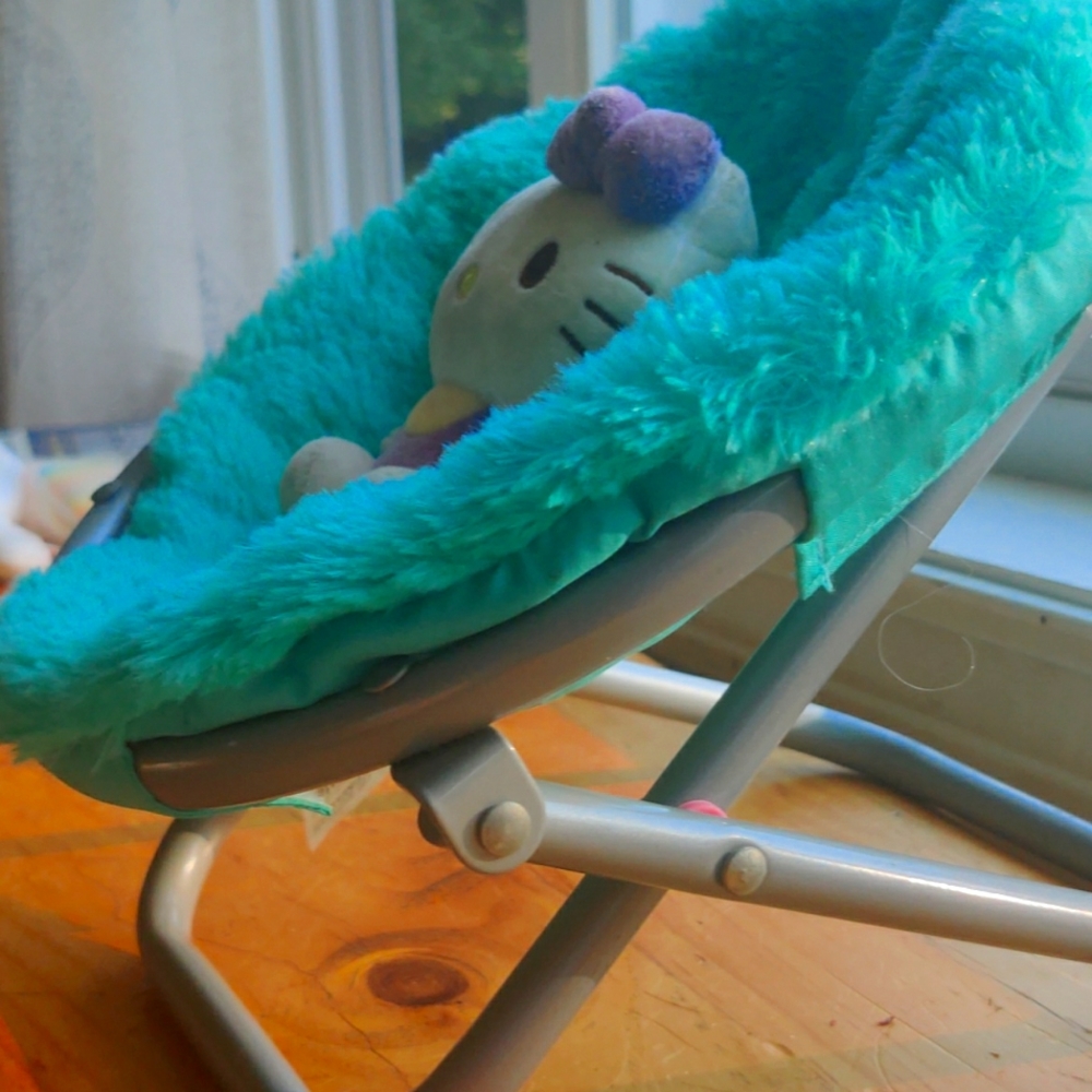 A kids toy chair with a mini hello Kitty inside
